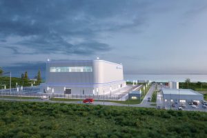 A rendering of what GE Hitachi's reactor may look like. It looks like a squat white box in the middle of a site with roads and grass areas surround the square site.