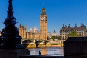 A stock photo of the Palace of Westminster taken from across the River Thames in day time with blue sky