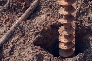 A stock photo of a borehole drill standing in a hole in the ground