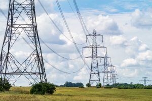A stock photo of electricity transmission pylons in the countryside